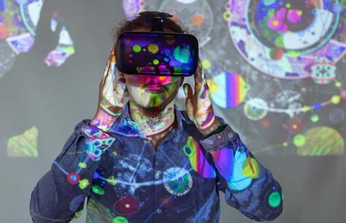 A man viewing an art exhibit through a VR headset.